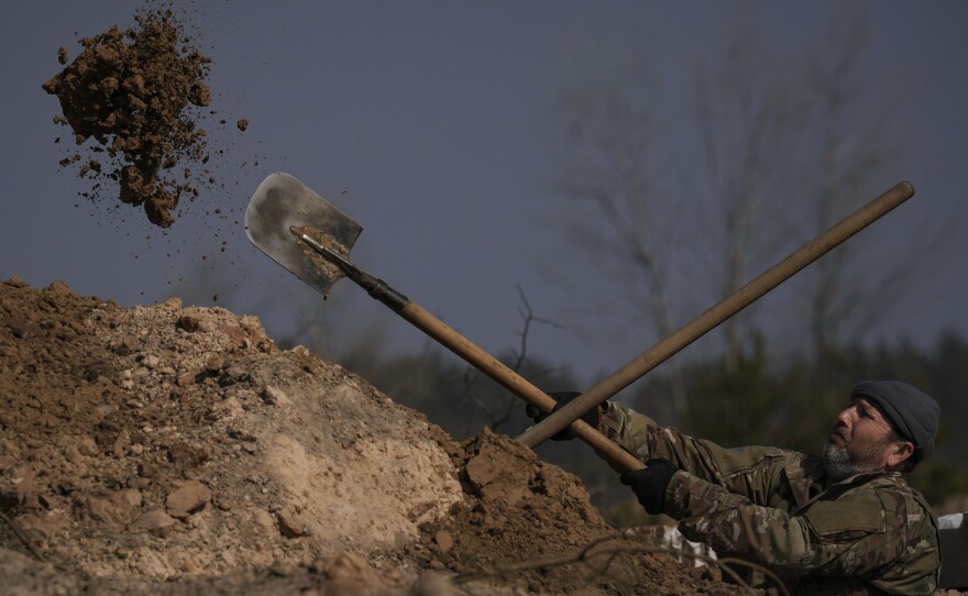 A Ukrainian serviceman digs a trench outside the capital Kyiv in March. Facing a more powerful Russian army, the Ukrainians have had to figure out ways to defend themselves. The Ukrainians have stressed basic measures, like digging deeper trenches to defend against Russian artillery, as well as high-tech methods, like using computer tablets on the battlefield to coordinate their artillery fire.