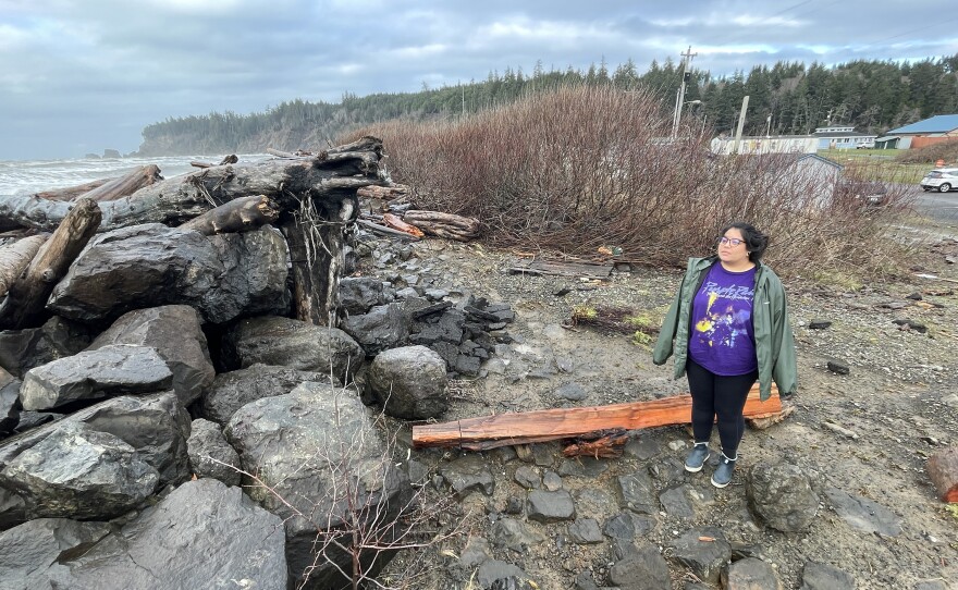 Lia Frenchman looks at the driftwood-covered sea wall behind her home in Taholah. At high tide during winter, the waves come into her backyard "and you'll see the water running under my house, out into the street," Frenchman said.