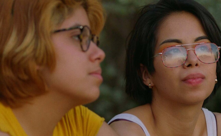 Silvia Del Carmen Castaños (left) and Estefanía “Beba” Contreras (right) sit by Lake Casa Blanca in Laredo watching the sunset and talking about their lives in scene from "Hummingbirds."
