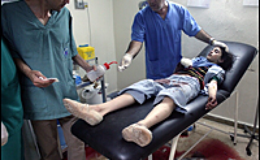 Doctors treat a wounded Lebanese civilian July 23, 2006, in Tyre, Lebanon. A family fleeing Tyre in a van was bombed by an Israeli warplane on Sunday.