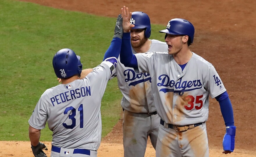 Joc Pederson of the Los Angeles Dodgers celebrates hitting a three-run home run in the ninth inning.