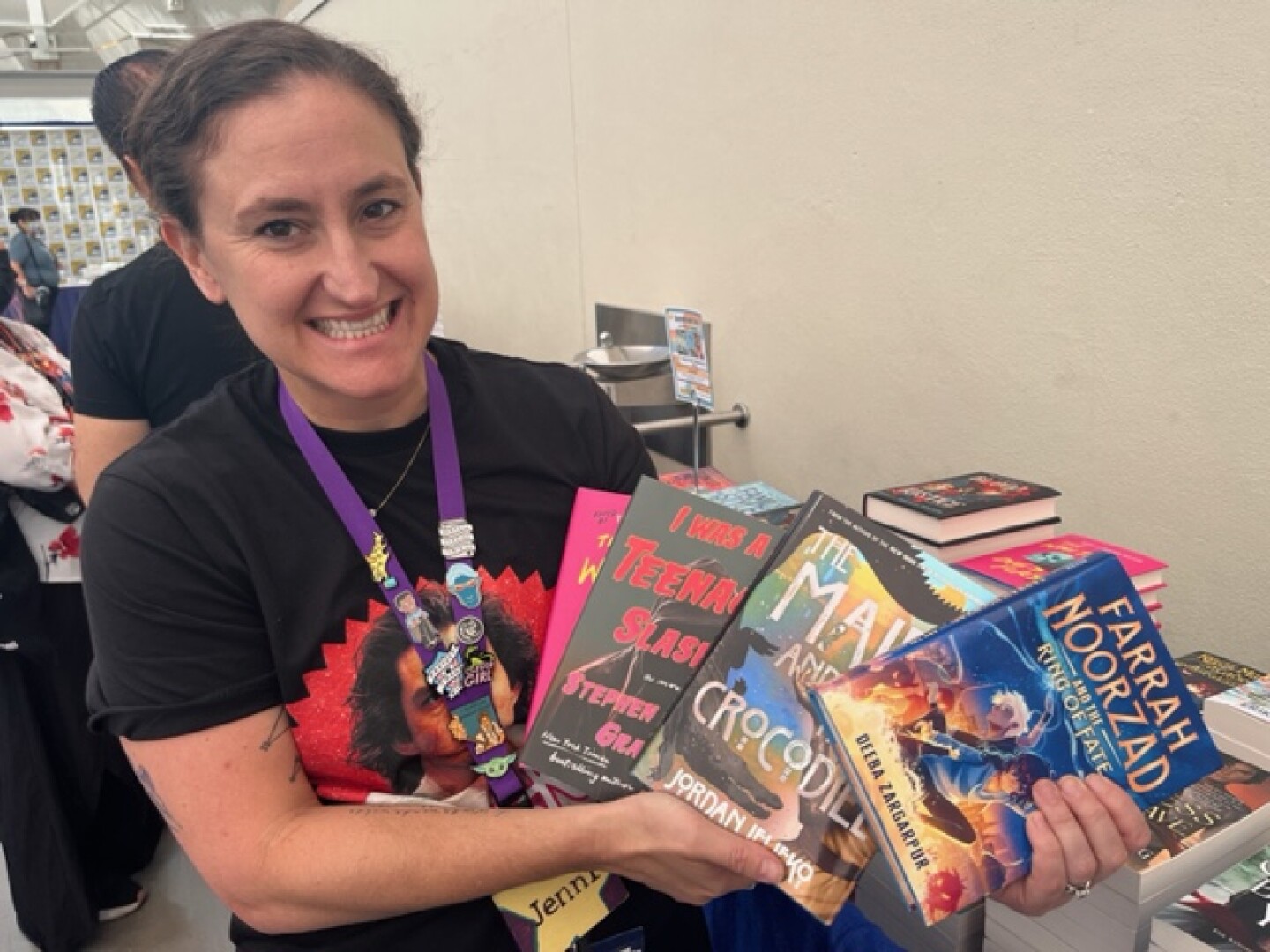 Jenni Marchisotto of Mysterious Galaxy bookstore holds copies of books she recommends on July 28, 2024 at the San Diego Convention Center.