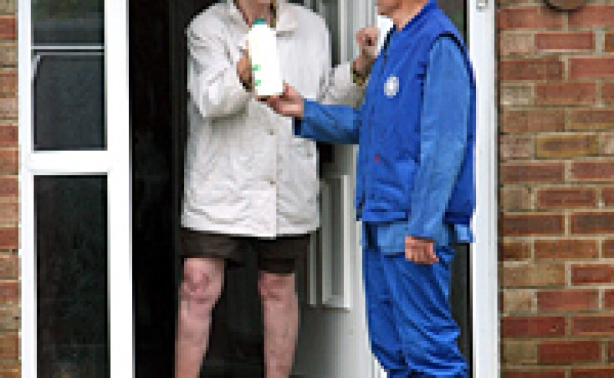 A milkman delivers milk to a flooded home Monday in Tewkesbury, Gloucestershire, England. Flooding has caused widespread disruption across the country, with further regions braced for more floods.