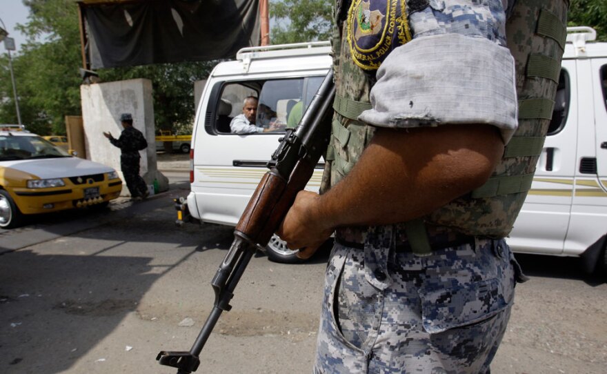 Iraqi police impose extra security measures after armed men attacked and killed five police officers before planting the black al-Qaida flag at a security checkpoint in Baghdad on Tuesday.