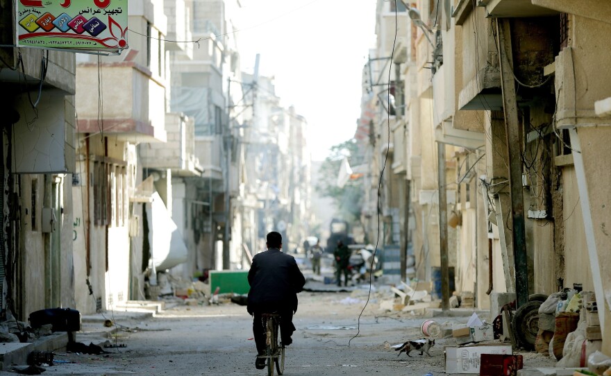 A bicyclist and a cat travel the streets of the modern town of Palmyra, adjacent to the ancient city, on Thursday. The AP describes the city as a ghost town.