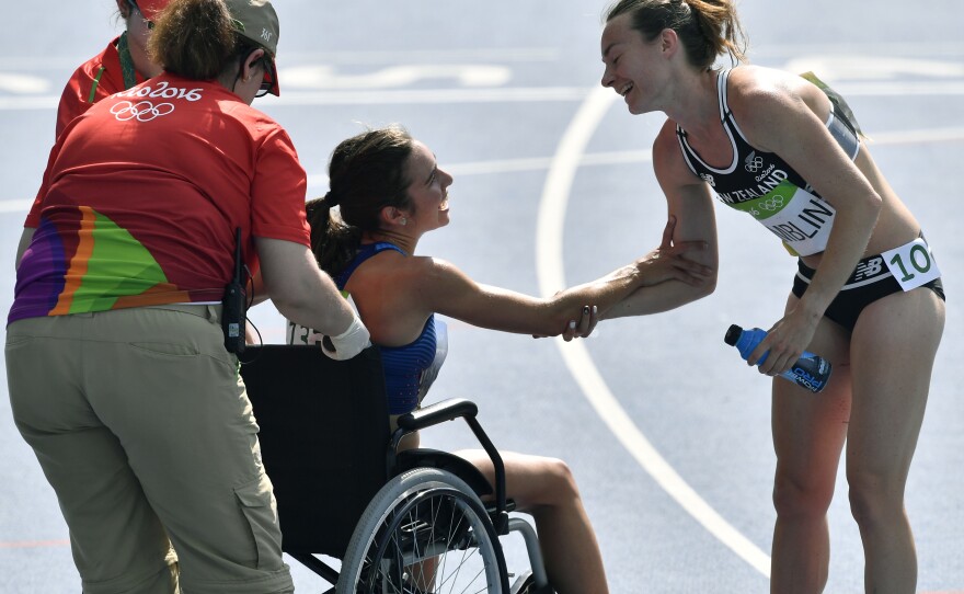 New Zealand's Nikki Hamblin (right) offers her support for America's Abbey D'Agostino as she is helped from the track after a heat in the women's 5,000 meters on Tuesday in Rio. Hamblin and D'Agostino fell during the race, and they encouraged each other to finish. Both advanced to the final because of the fall, but D'Agostino will not be able to run because of a torn ACL.