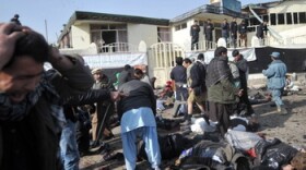 A man grieves as others try to help victims and remove bodies from the scene in Kabul earlier today (Nov. 6, 2011) after a suicide bomb exploded in a crowd of Shiite worshipers.