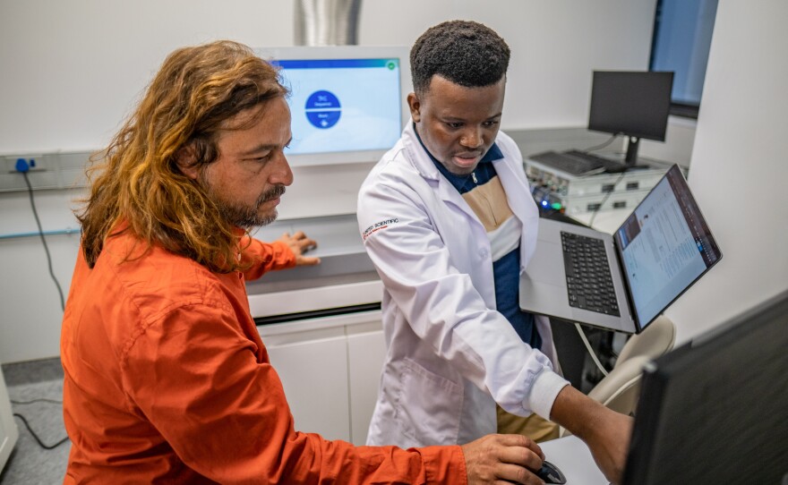 Tulio de Oliveira collaborates on a project with fellow scientist Wonderful Choga, who is visiting from Botswana. The center he directs in Cape Town has become a hub for researchers from across the Global South to develop even more advanced processes for determining the genetic code of pathogens.