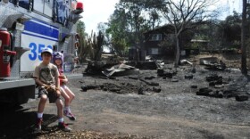 Children are pictured in front of a home that burned in Harmony Grove, May 2014.

