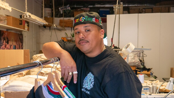 Moss Randy Ortega leans against a clothing rack for a portrait at Norma's Apparel in National City on Aug. 3, 2026.