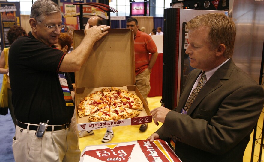 Patrick McCoy, right, and Harry Fowler, of the Schwan Food Company show off their company's Big Daddy pizza at the School Nutrition Association's national conference in Chicago in 2007. School pizza producer The food company has lately been lobbying on the school nutrition issue in favor of the school waiver.