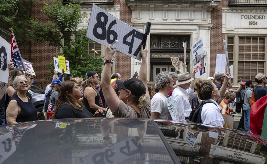 A demonstrator holds up an "8647" sign at a "No Kings" protest in Louisville, Ky., in June 2025. It's an anti-Trump slogan, with multiple interpretations.