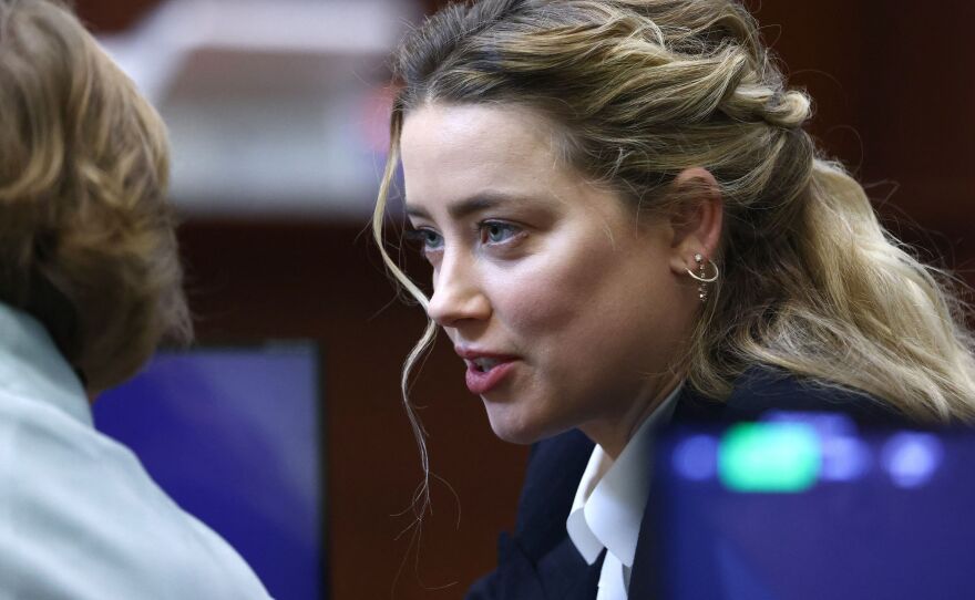 Actress Amber Heard speaks to her attorney during the defamation trial against her at the Fairfax County Circuit Courthouse in Fairfax, Va., on Thursday.