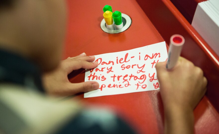 Aiden writes a letter to Daniel, a fictional boy who teaches children about the holocaust. The children's exhibit at the United States Holocaust museum has a space for children to write a letter to Daniel after walking through his story.
