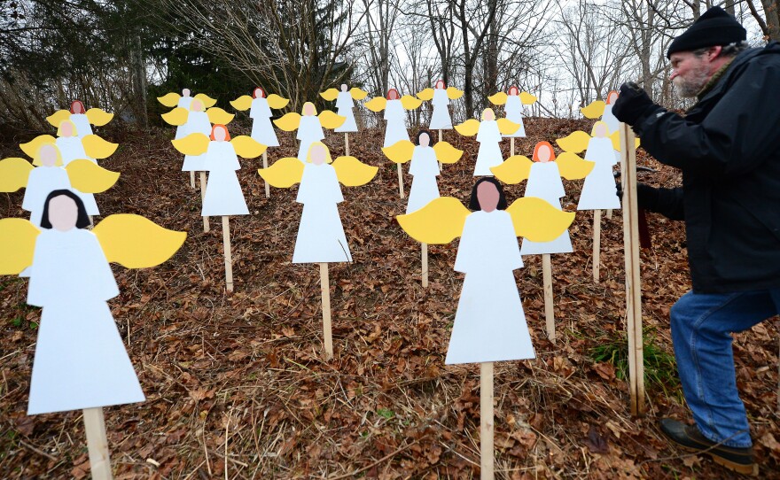 On a hillside in Newtown, Conn., art teacher Eric Mueller sets up wooden angels in memory of the victims of the Sandy Hook Elementary School shooting. Details about the lives of the slain are showing the depths of the community's loss.