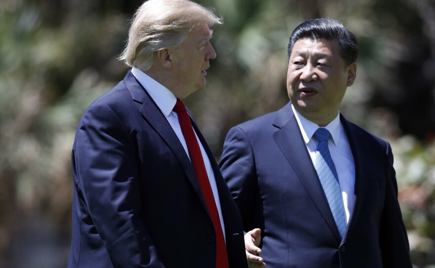 President Donald Trump and Chinese President Xi Jinping walk together after their meetings at Mar-a-Lago, on Friday, April 7, 2017, in Palm Beach, Fla.