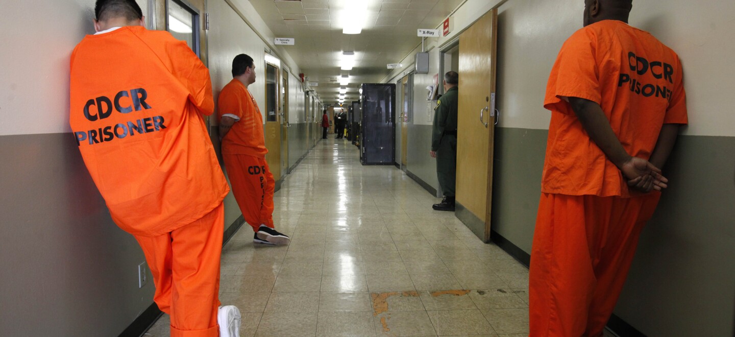 In this Jan. 12, 2012, file photo, inmates wait in the hallway for treatment at the infirmary of the Deuel Vocational Institute near Tracy, Calif.
