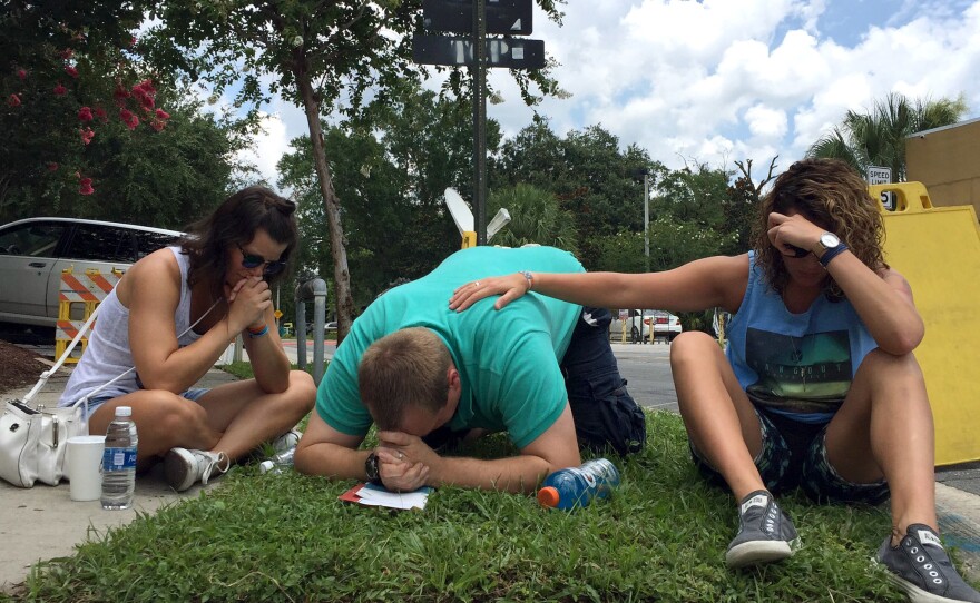 People pray on Orange Ave. in Orlando, near the Pulse night club.