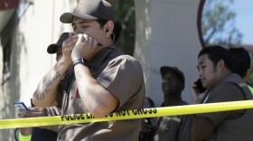 UPS workers gather outside a UPS package delivery warehouse where a shooting took place in San Francisco, June 14, 2017.