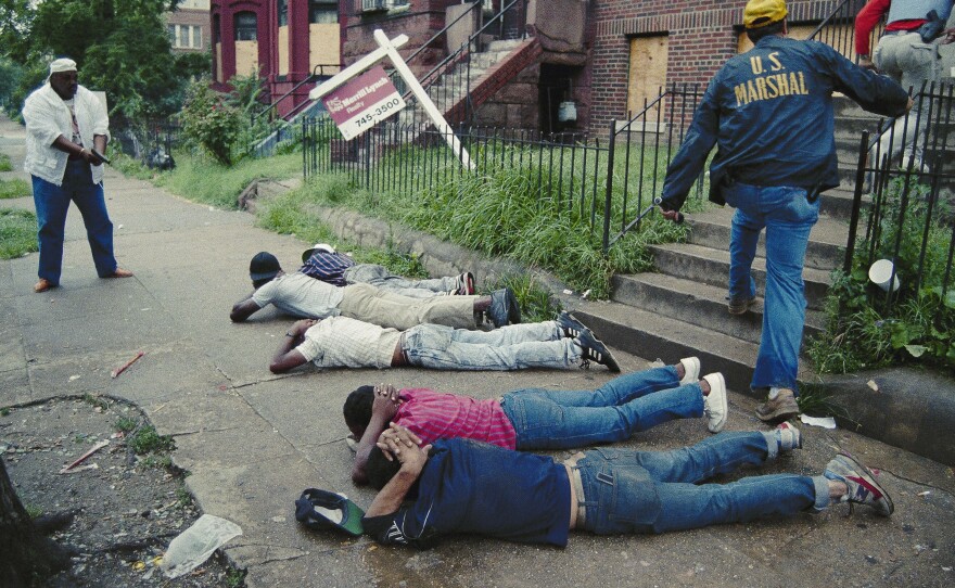 In this photo, released July 17, 1989, a U.S. marshal keeps his pistol trained on suspects as other marshals raid a crack house in Washington, D.C. The city's crack epidemic lasted from the late '80s to the early '90s.