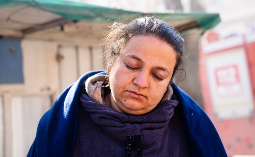 Melike Bayar, 34, cries as she stands outside the building where her relatives died.