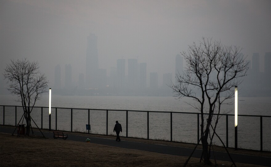 A man walks along the Yangtze River in Wuhan, the city in China where the novel coronavirus was first identified.