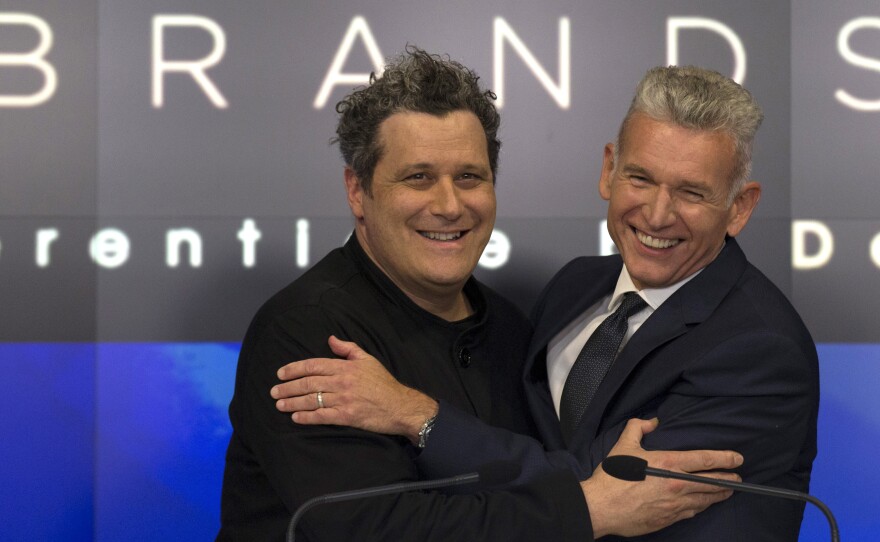 Designer Isaac Mizrahi (left) embraces Robert D'Loren, CEO of Xcel Brands, which once manufactured 70% of its clothes in China. Today that's down to about 20%. The company now manufacturers in a variety of countries, including Indonesia, India and Sri Lanka.
