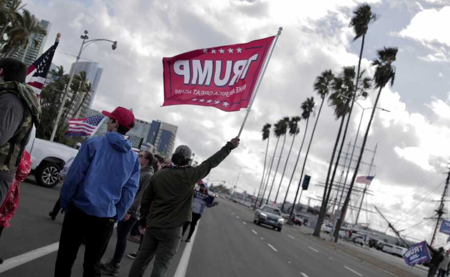 San Diego residents fly flags and hold signs in support of Donald Trump on North Harbor Drive in Downtown, in this Nov. 7, 2020 photo.