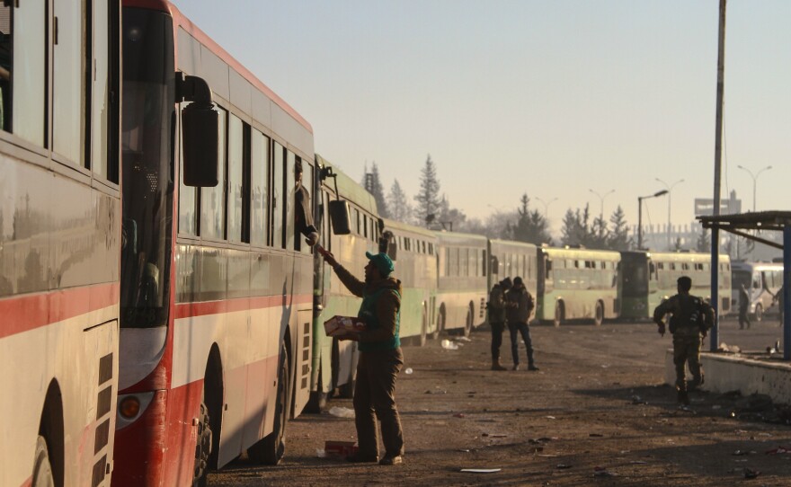 Civilians evacuated from east Aleppo arrive in Syria's Rashidin region on Monday. A series of cease-fire and evacuation deals have been negotiated, broken and re-negotiated over the last few days.