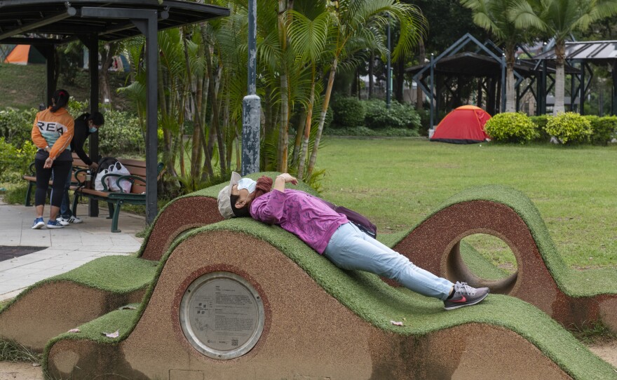 New rules in Hong Kong require everyone to wear a mask in all outdoor places or face a $650 fine. Above: A masked woman stretches out a public park. Also: The maximum number of people allowed at a public gathering is ... 2.