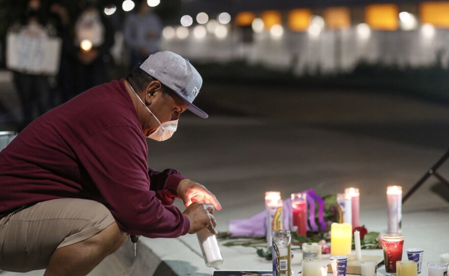 A man sets a candle outside the Otay Mesa Detention Center during a "Vigil for Carlos" on May 9 in San Diego. The vigil was held to commemorate Carlos Ernesto Escobar Mejia, who died of COVID-19-related symptoms at the detention center.