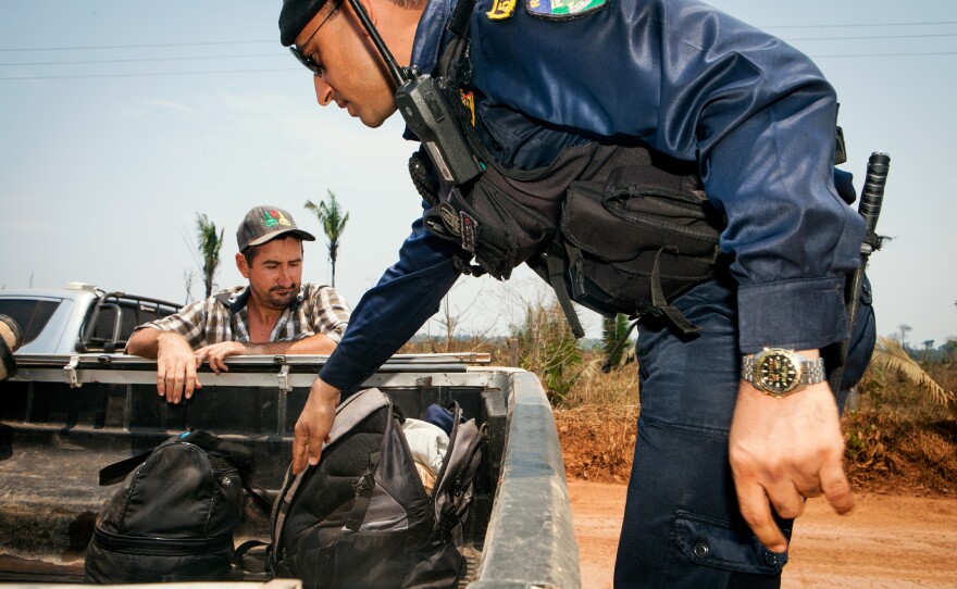 The environmental authorities, working in a convoy that consists of large pickup trucks, stop passersby and inspect their cars for signs of illegal activity.