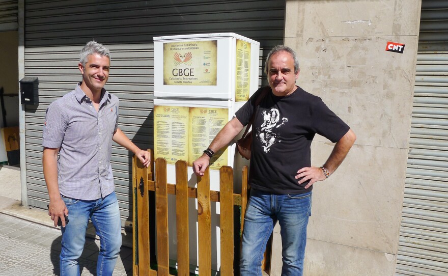 Galdakao Mayor Ibon Uribe (left) and volunteer Javier Goikoetxea pose in front of the Solidarity Fridge, Spain's first communal refrigerator, shared by citizens in Galdakao, a city outside Bilbao.