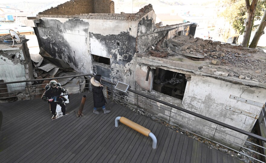 In January, a woman looks at wrecked homes hit by North Korea's 2010 shelling attack at a museum that displays materials related to the attack.