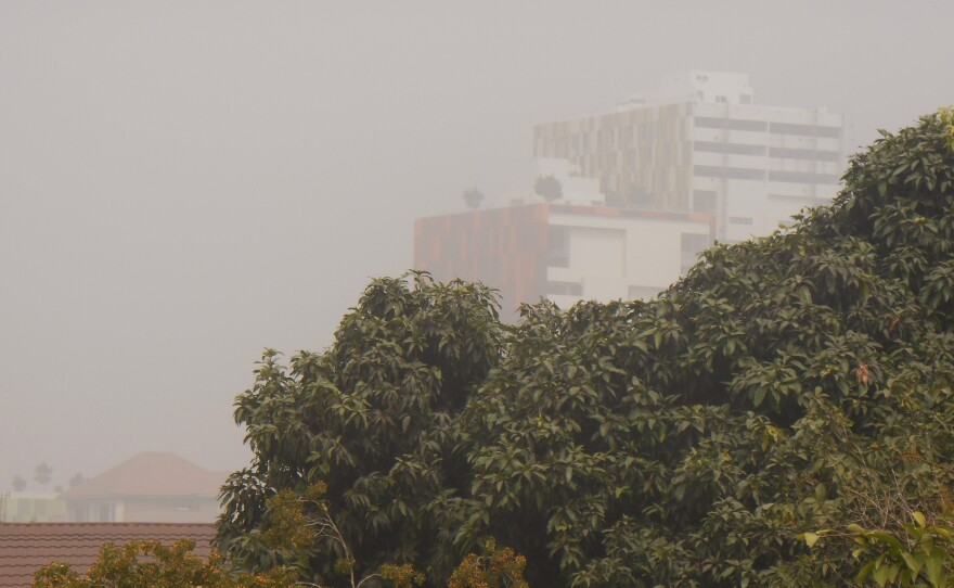 The view from the author's home in Accra, Ghana. The buildings in the background are typically bright green and red, but a blanket of Harmattan haze has dulled their colors.