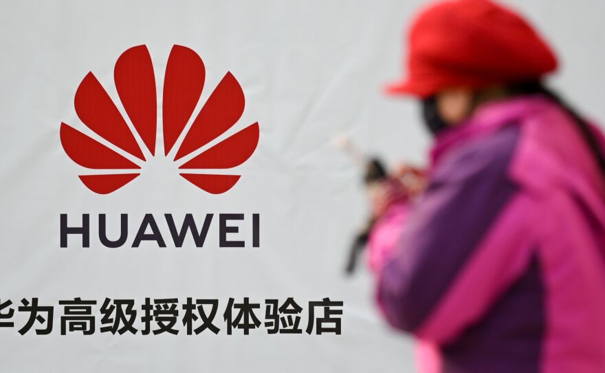 A Justice Department indictment unsealed on Monday details an alleged conspiracy by the Chinese device maker Huawei to steal the details of a T-Mobile robot. Here, a woman uses her smartphone outside a Huawei store in Beijing on Tuesday.