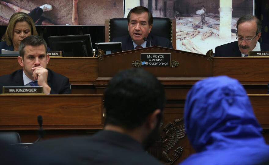 Rep. Ed Royce (center), a California Republican, speaks during an July 2014 hearing of the House Foreign Affairs Committee, with "Caesar," a Syrian army defector who wore a blue, hooded jacket to protect his identity. Ceasar smuggled out of Syria more than 55,000 photographs that document the torture and killings in Syrian prisons.