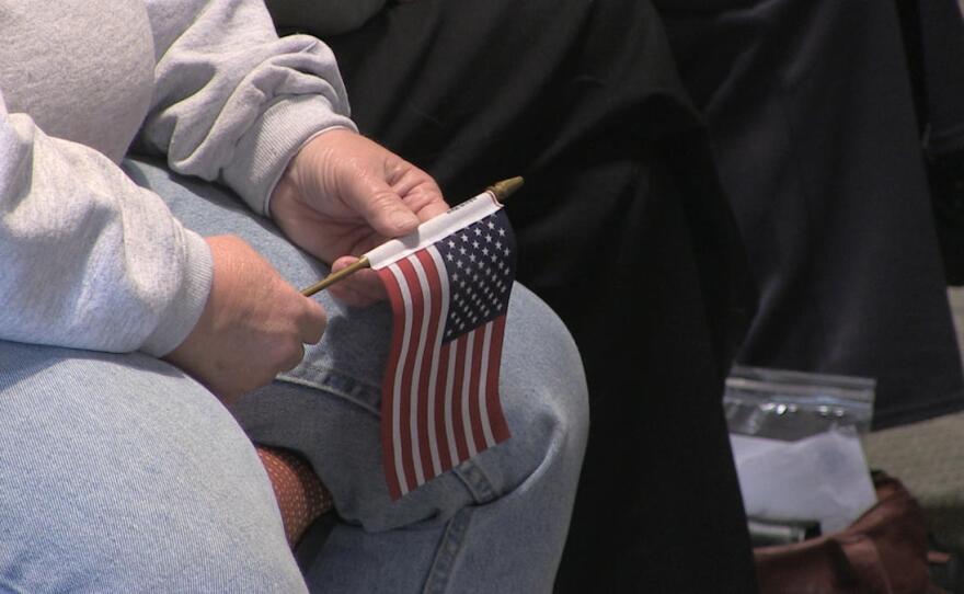 A man holds a small American flag at a naturalization ceremony in Las Cruces, New Mexico, Jan. 15, 2016.