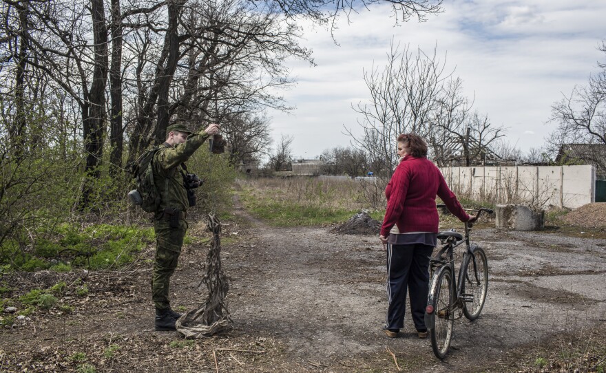 Lt. Mikhail Andronik, a soldier in the Donetsk People's Republic Army, shows an exploded artillery to Vera Anoshina, 52, a local resident.