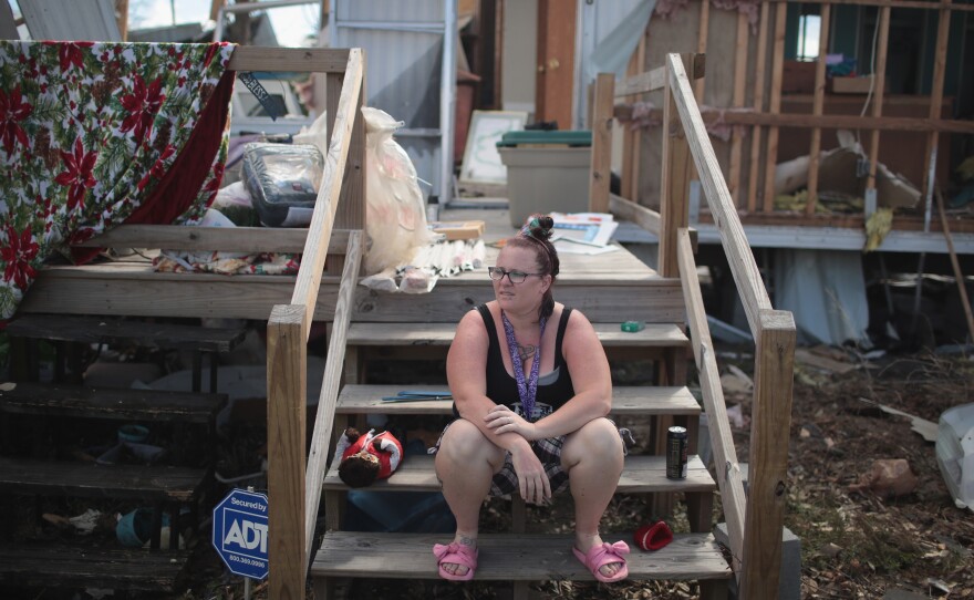 Kimbrely Brock sits on the steps of a friend's trailer that was destroyed by Hurricane Michael in Panama City, Fla., in October. President Trump holds a political rally in Panama City Wednesday.
