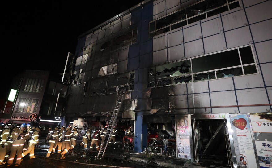 Firefighters make their way into a building on Dec. 21, 2017 in Jecheon, South Korea. The death toll jumped to 29 as rescue workers searched a scorched, smoke-filled commercial building in the southern city of Jecheon after a fire engulfed the building, firefighters said.