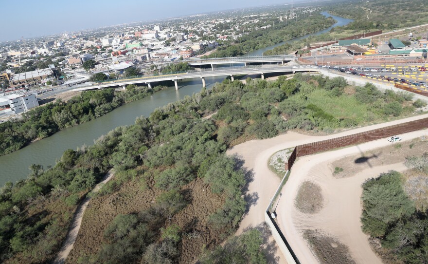 A U.S. Customs and Border Protection helicopter patrol flies over a border fence by a bridge between the United States and Mexico on Oct. 18, 2016 in Hidalgo, Texas.