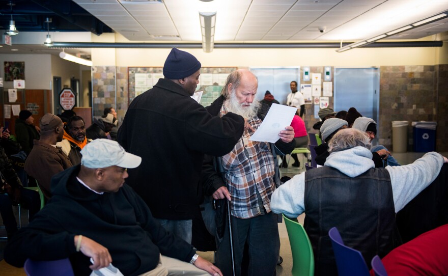 At Health Care for the Homeless, Simmons helps a man named Ethan with some literature about the clinic's services.