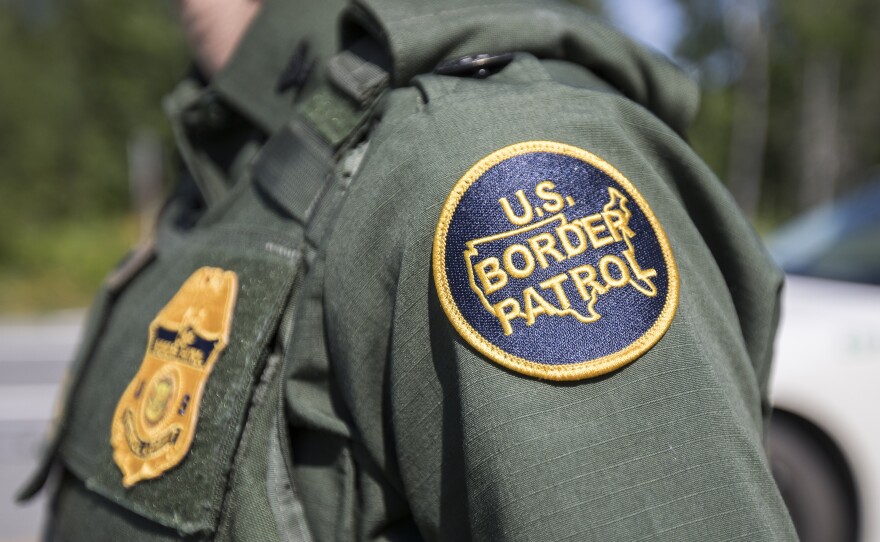 A U.S. Border Patrol agent stands at a highway checkpoint on August 1 in West Enfield, Maine.