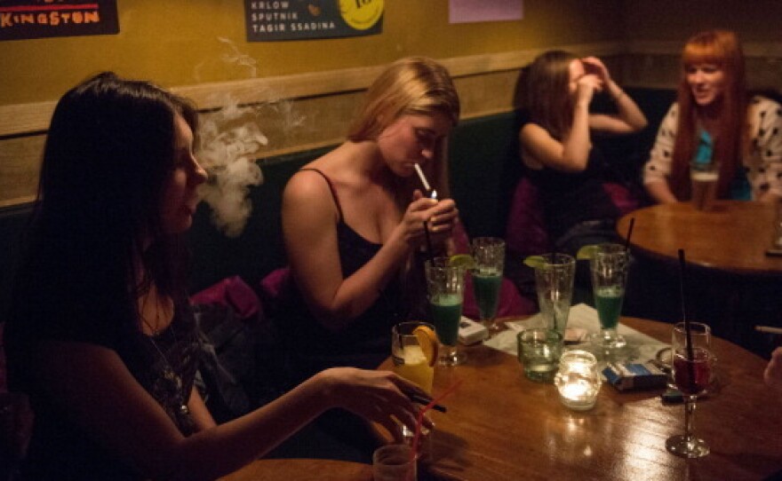 Women smoke in a Moscow bar in May. Tough new anti-smoking rules took effect Sunday in Russia, banning smoking in bars, restaurants, and other public spaces.