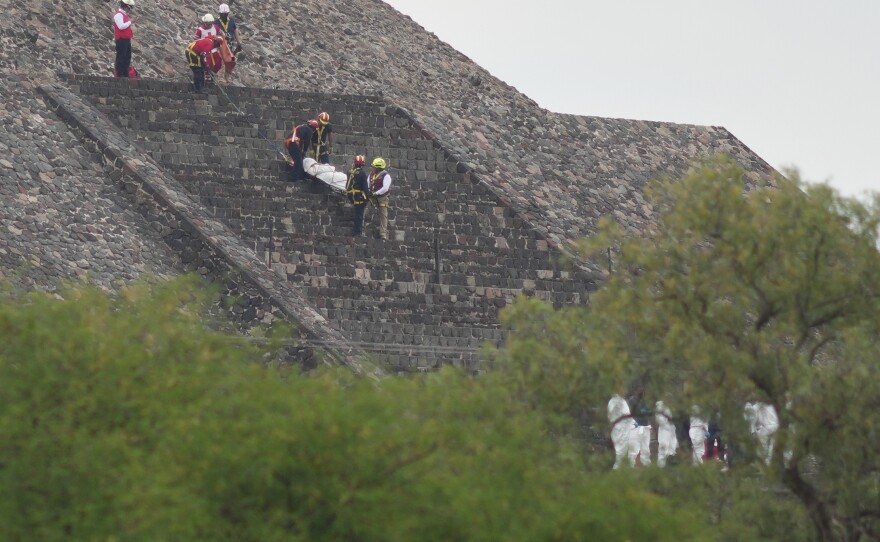 Forensic workers carry the body of a victim down a pyramid after authorities said a gunman opened fire, in Teotihuacan, Mexico, Monday, April 20, 2026.