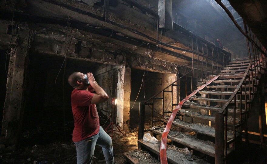 An Iraqi man looks for victims at the bomb site in Baghdad.