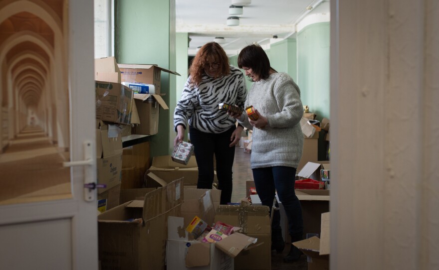 Volunteers at a youth center pack boxes of groceries and toiletries for Ukrainians displaced by the war.