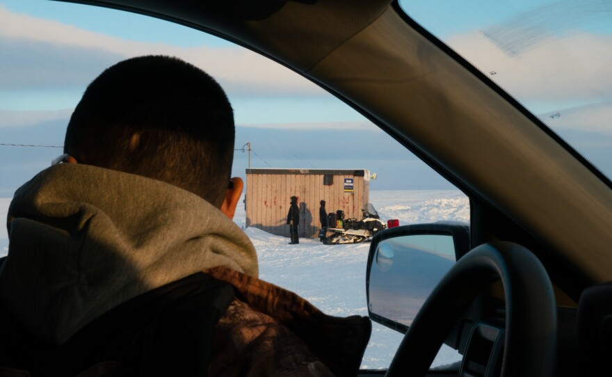 People wait for a plane to arrive at the airstrip in Toksook Bay.