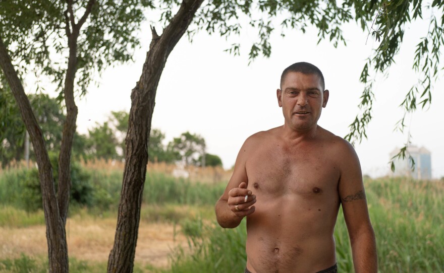 Sergiy Belous, a truck driver waiting at the port of Izmail, stands near a marshy area where he says he's been bathing while biding his time to offload his truck.